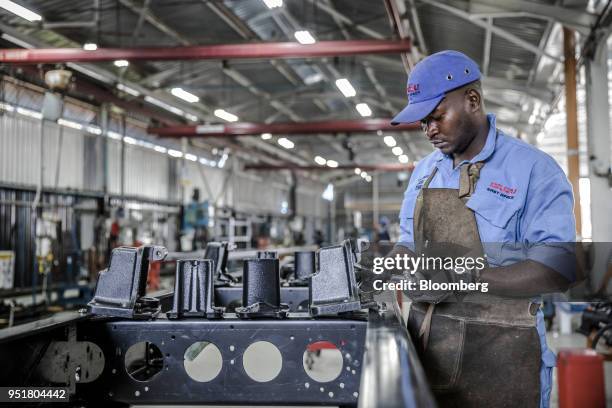 An employee works on the chassis of an Isuzu truck on the assembly line inside the Isuzu East Africa Ltd. Plant in Nairobi, Kenya, on Thursday, April...