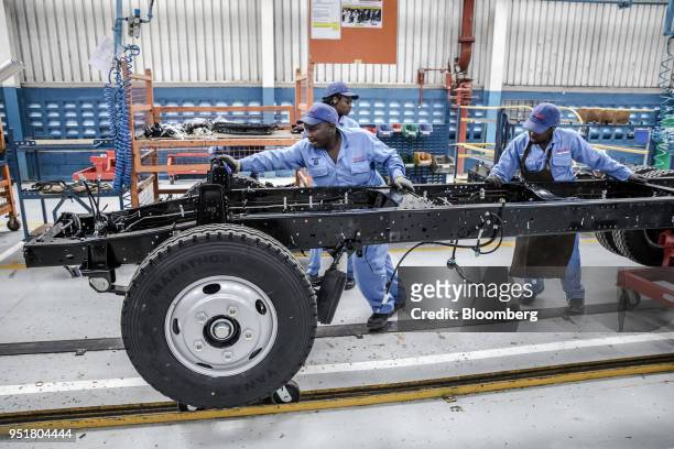 Employees move the chassis of an Isuzu truck on the assembly line inside the Isuzu East Africa Ltd. Plant in Nairobi, Kenya, on Thursday, April 26,...