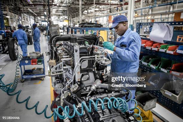 An employee works on the engine of an Isuzu truck on the assembly line inside the Isuzu East Africa Ltd. Plant in Nairobi, Kenya, on Thursday, April...