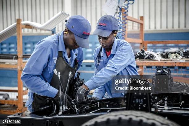 Employees work affixing electronics to the chassis of an Isuzu truck on the assembly line inside the Isuzu East Africa Ltd. Plant in Nairobi, Kenya,...