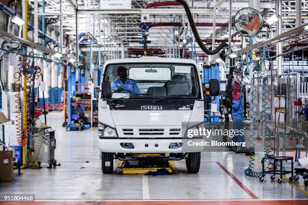 An employee sits in the cabin of an Isuzu NPR N-Series truck on the assembly line inside the Isuzu East Africa Ltd. Plant in Nairobi, Kenya, on...