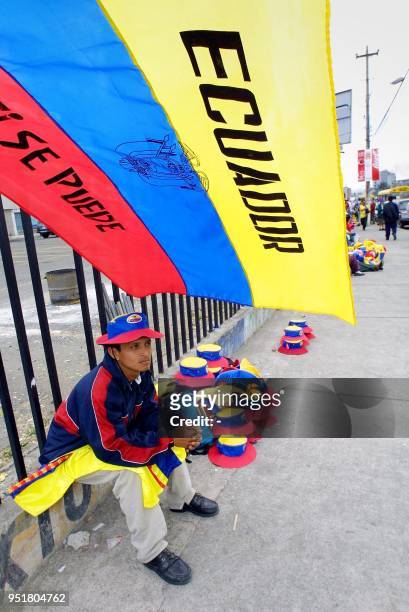 Vendor is seen selling hats and flags in Quito, Ecuador 06 November 2001. Un comerciante ofrece a la venta banderas y sombreros de Ecuador en una...