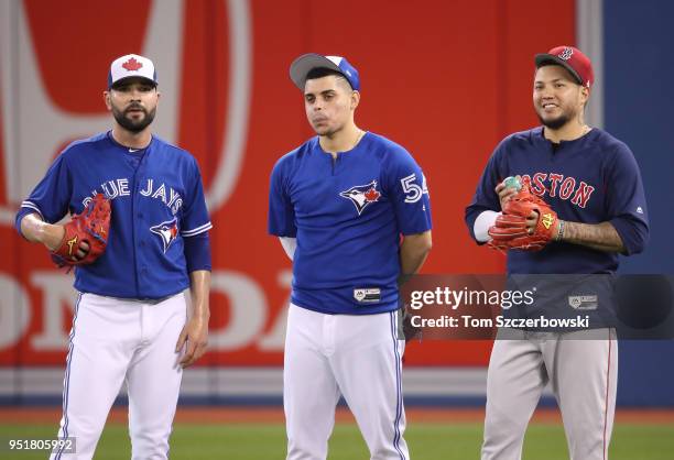 Jaime Garcia of the Toronto Blue Jays talks to Roberto Osuna and Hector Velazquez of the Boston Red Sox during batting practice before their MLB game...