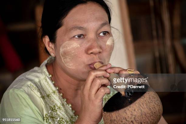donna fuma cheroot nel mercato di bagan. - cheroot foto e immagini stock