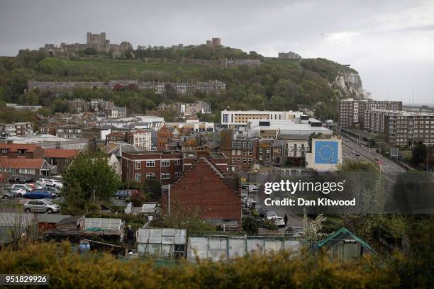 Painted mural by British graffiti artist Banksy, depicting a workman chipping away at one of the stars on a European Union themed flag stands in the...