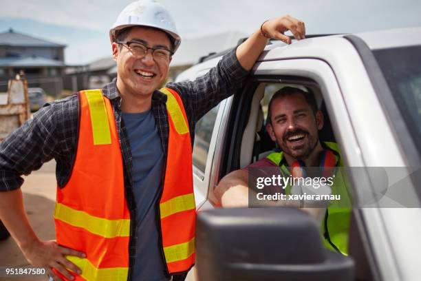 worker smiling by colleague sitting in car at site - construction manager stock pictures, royalty-free photos & images