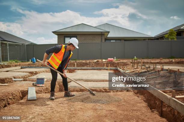 vorarbeiter, die verbreitung von trockenen zements auf baustelle - building a home australia stock-fotos und bilder