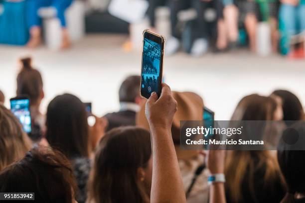 An alternative view of the audience with cell phones recording and live with facebook live, instagram, snapchat at Juliana Jabour fashion show during...