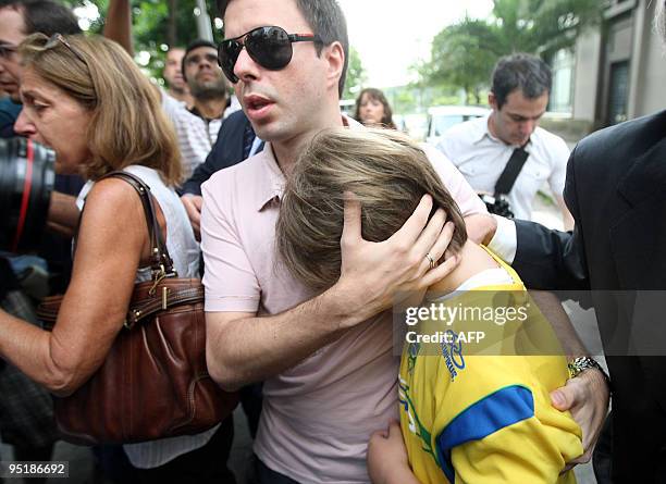 Nine-year-old boy Sean Goldman embraces his stepfather, Brazilian Joao Paulo Lins e Silva upon arrival at the US consulate in Rio de Janeiro, Brazil,...