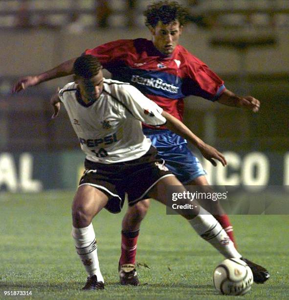 Gil , of the Corinthians, in Brazil, fights for the ball againast an unidentified player on the Universidad Catolica team, of Chile, 31 October 2001...