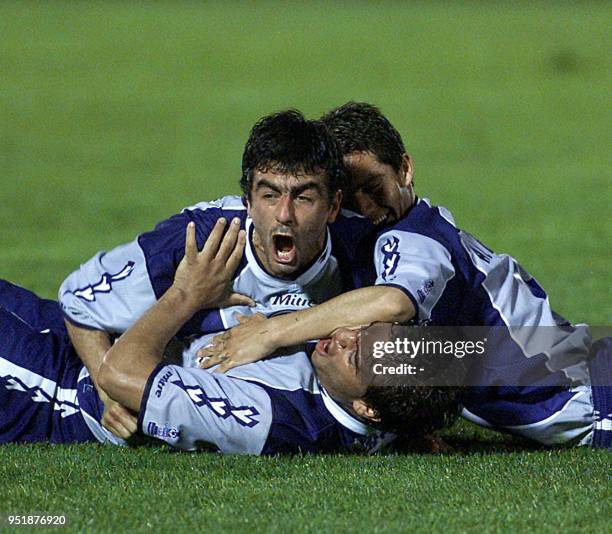 Pablo Cubas hugs his teamates Daniel Albornoz and Adrian Avalos , 17 October 2001, in Montevideo after they scorred their first goal. Pablo Cubas es...