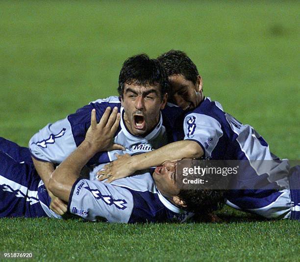 Pablo Cubas hugs his teamates Daniel Albornoz and Adrian Avalos , 17 October 2001, in Montevideo after they scorred their first goal. Pablo Cubas es...