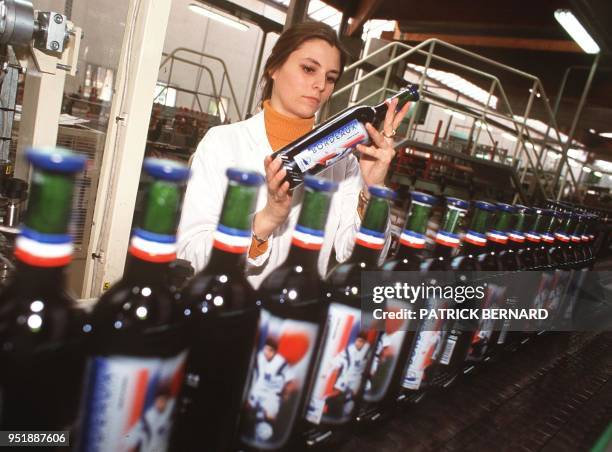 Une employée de l'entreprise des caves de Landiras, surveille la chaîne de production de la cuvée officielle du mondial 98, le 8 mai à Landiras, près...