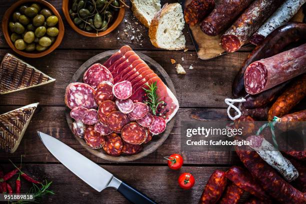 mixed spanish chorizo slices plate on rustic wooden table - curing food stock pictures, royalty-free photos & images