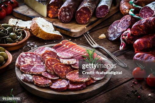 Mixed spanish chorizo slices plate on rustic wooden table Mixed spanish chorizo slices plate on rustic wooden table