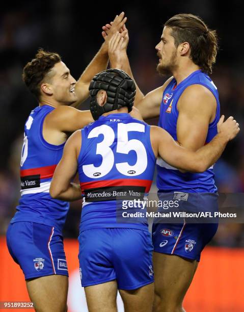 Luke Dahlhaus, Caleb Daniel and Tom Boyd of the Bulldogs celebrate during the 2018 AFL round six match between the Western Bulldogs and the Carlton...