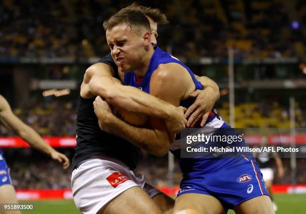 Hayden Crozier of the Bulldogs is tackled by Matthew Wright of the Blues during the 2018 AFL round six match between the Western Bulldogs and the...