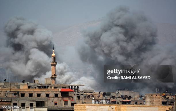 Picture taken in the Yarmuk Palestinian refugee camp in southern Damascus on April 27, 2018 shows smoke billowing in the area during Syrian army...