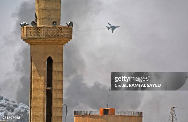 Picture taken in the Yarmuk Palestinian refugee camp in southern Damascus on April 27, 2018 shows a Syrian army plane flying over the area during...