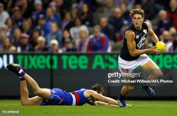 Charlie Curnow of the Blues evades Zaine Cordy of the Bulldogs during the 2018 AFL round six match between the Western Bulldogs and the Carlton Blues...