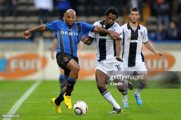 Club Brugges' Wilfried Dalmat fights for the ball with PAOK Salonika's Lino during the Europa League football match between Club Brugges and Greek...