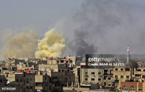Picture taken in the Yarmuk Palestinian refugee camp in southern Damascus on April 27, 2018 shows smoke billowing in the area during Syrian army...