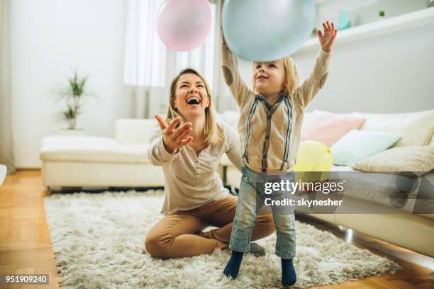 speelse moeder en zoon plezier met ballonnen in de woonkamer. - living room kids stockfoto's en -beelden