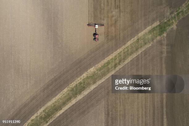 Case IH Agricultural Equipment Inc. Tractor pulls a planter through a field as corn in planted in this aerial photograph taken over a farm in...