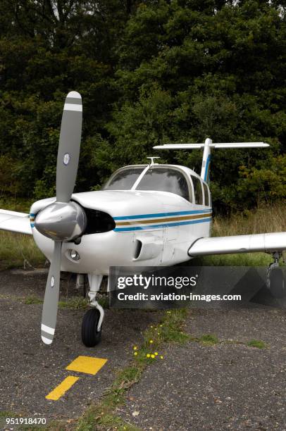 Propellers and nosewheel undercarriage of Piper PA-32RT-300T Cherokee Lance II parked on the grass.
