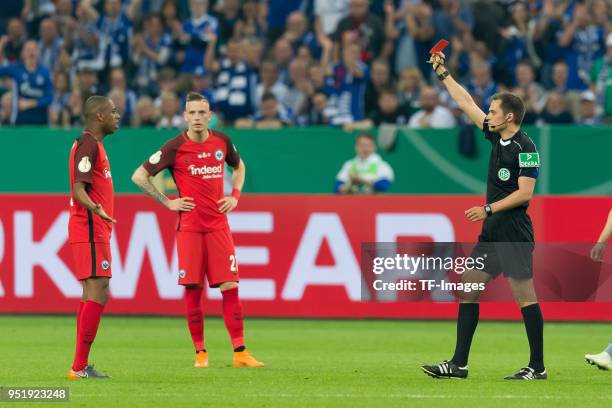 Referee Robert Hartmann shows a red card to Gelson Fernandes of Frankfurt during the DFB Cup semi final match between FC Schalke 04 and Eintracht...