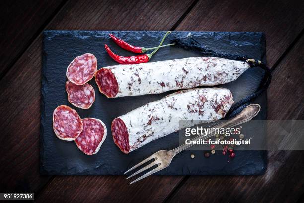 spanish chorizo shot from above on rustic wooden table - salami stock pictures, royalty-free photos & images