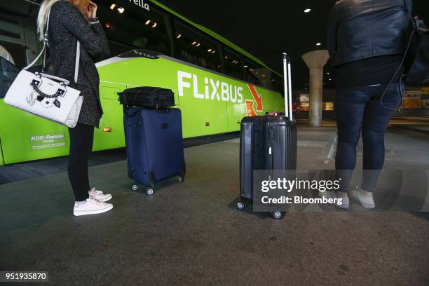 Travelers stand with their luggage beside a FlixBus passenger bus at Munich central bus station in Munich, Germany, on Friday, April 27, 2018. Since...