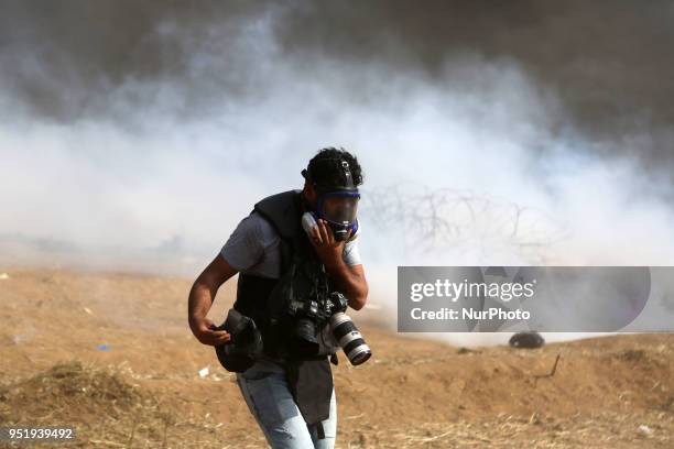 Photojournalist runs during clashes between Israeli troops and Palestinians at a protest where Palestinians demand the right to return to their...