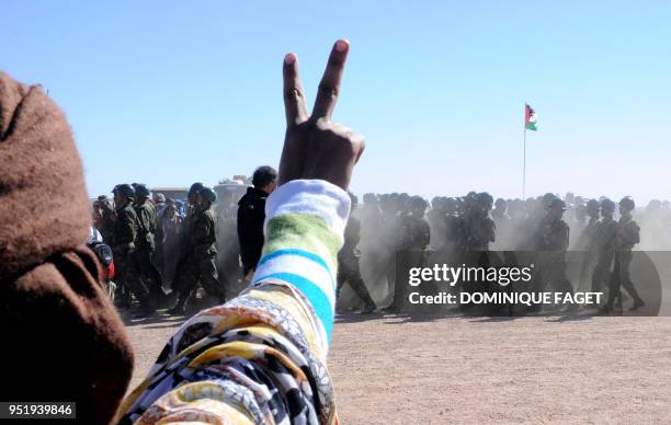 Man flashes a v-sign as soldiers from the Pro-independence Polisario Front parade during a ceremony marking the 35th anniversary of the proclamation...