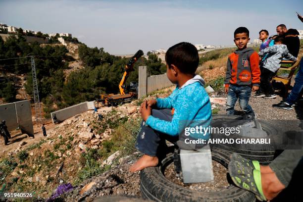 Picture taken on April 27, 2018 shows Palestinians from the Shuafat refugee camp in east Jerusalem watching as Israeli forces replace the collapsed...