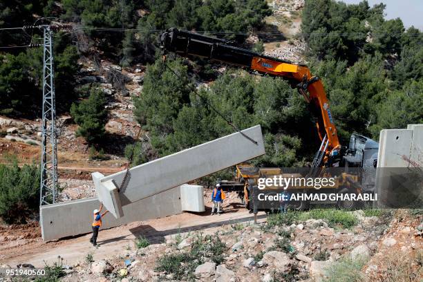 Picture taken on April 27, 2018 shows Israeli forces replacing the collapsed sections of the controversial Israeli separation wall, dividing the camp...