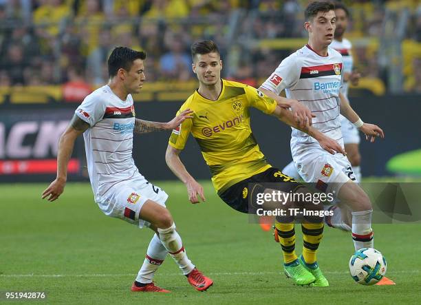 Charles Aranguiz of Leverkusen, Julian Weigl of Dortmund and Kai Havertz of Leverkusen battle for the ball during the Bundesliga match between...