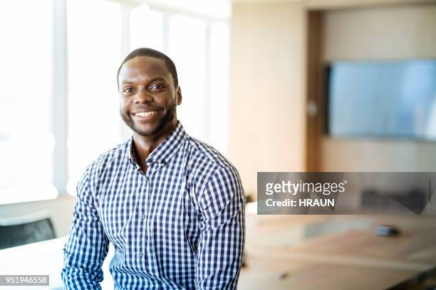portrait of smiling young businessman at office - black shirt stock pictures, royalty-free photos & images