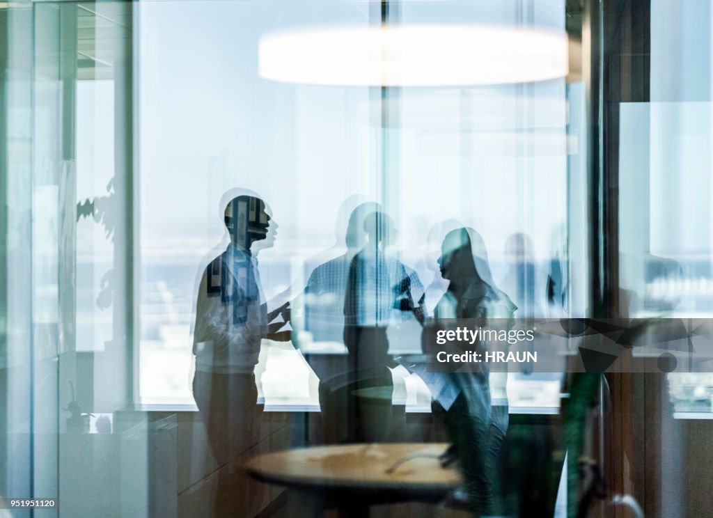 Business colleagues seen through glass at office