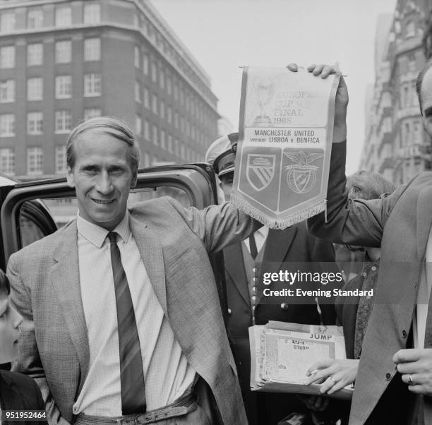 English soccer player Bobby Charlton of Manchester United FC holding a commemorative pennant of the European Cup final against SL Benfica, London,...