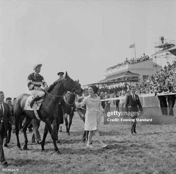 English jockey Lester Piggott on top of American-bred Irish-trained Thoroughbred racehorse Sir Ivor, led by Princess Caroline Murat , after winning...