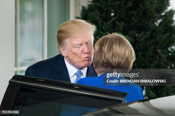 President Donald Trump kisses German Chancellor Angela Merkel as he welcomes her to the White House on April 27, 2018 in Washington,DC.