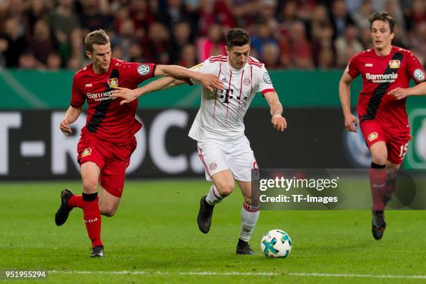 Sven Bender of Leverkusen and Robert Lewandowski of Muenchen battle for the ball during the DFB Cup semi final match between Bayer 04 Leverkusen and...