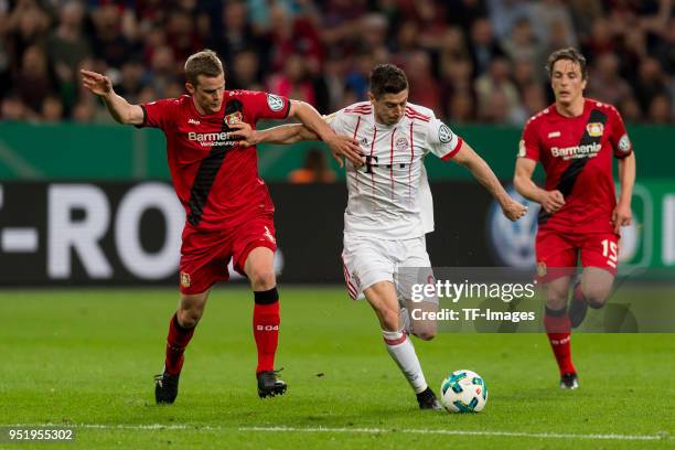 Sven Bender of Leverkusen and Robert Lewandowski of Muenchen battle for the ball during the DFB Cup semi final match between Bayer 04 Leverkusen and...