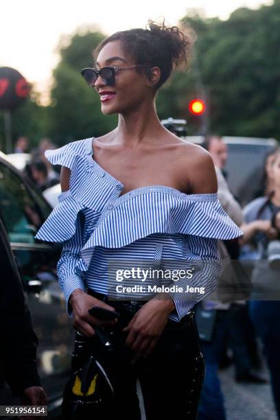 Jourdan Dunn wears black Dior Sunglasses, a Self-Portrait Striped Frill Asymmetric Blue & Shirt off-shoulder Shirt, and black leather Topshop pants...