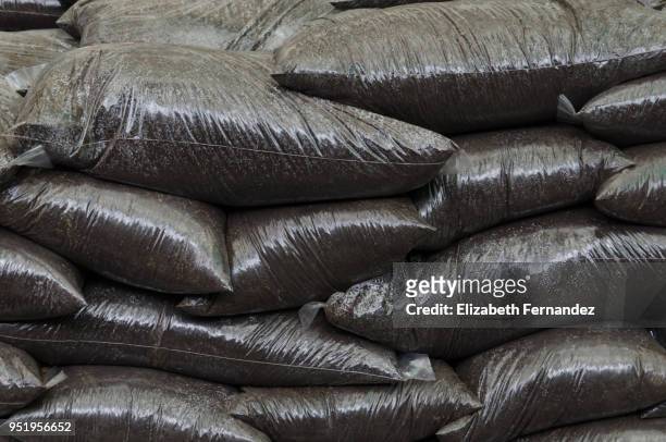 a stack of bags of top soil in a garden centre - top soil stock pictures, royalty-free photos & images