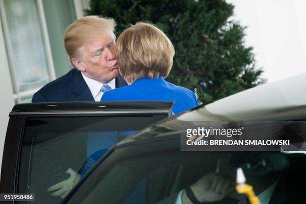 President Donald Trump kisses German Chancellor Angela Merkel as he welcomes her to the White House on April 27, 2018 in Washington,DC.