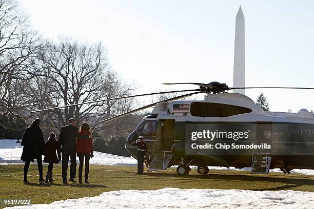 President Barack Obama, first lady Michelle Obama and their children Sasha and Malia walk across the South Lawn before boarding Marine One and...