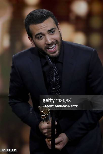 Elyas M'Barek accepts the award 'Biggest Movie Audience' for the film 'Fack ju Goehte' on stage during the Lola - German Film Award show at Messe...
