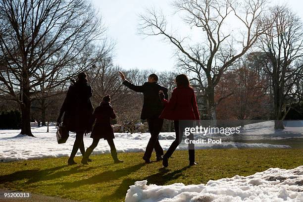 President Barack Obama, first lady Michelle Obama and their children Sasha and Malia walk across the South Lawn before boarding Marine One and...